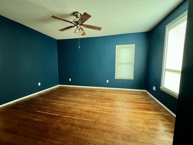 112 W 6th St, Fulton, MO 65251 - empty room with wood finished floors, a textured ceiling, a ceiling fan, and baseboards
