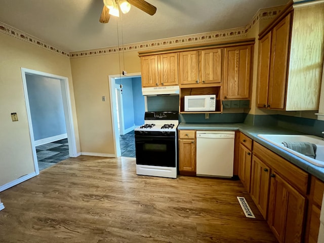 112 W 6th St, Fulton, MO 65251 - kitchen featuring white appliances, under cabinet range hood, a ceiling fan, wood finished floors, and a sink