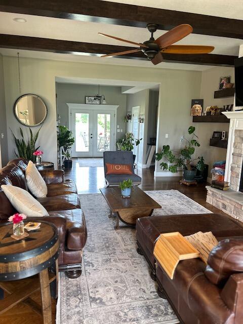15172 S Henry Ln, Ashland, MO 65010 - living area featuring ceiling fan, french doors, a stone fireplace, beamed ceiling, and wood finished floors