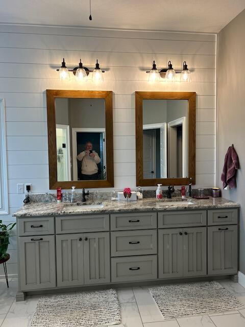 15172 S Henry Ln, Ashland, MO 65010 - bathroom featuring marble look tiles, double vanity, and wood walls