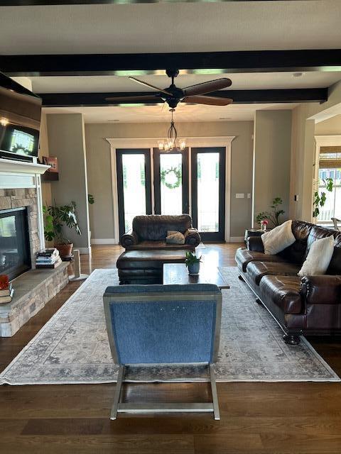 15172 S Henry Ln, Ashland, MO 65010 - living area with baseboards, a stone fireplace, ceiling fan, beam ceiling, and wood finished floors
