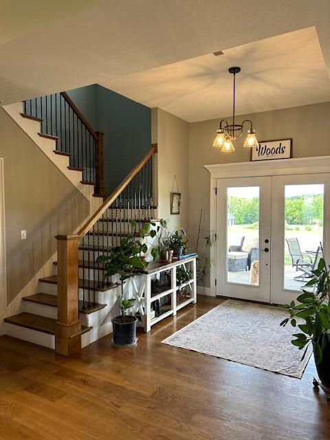 15172 S Henry Ln, Ashland, MO 65010 - foyer entrance featuring stairs, french doors, wood finished floors, and a chandelier
