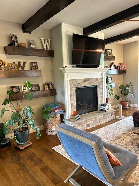 15172 S Henry Ln, Ashland, MO 65010 - living area featuring beam ceiling, wood finished floors, a stone fireplace, and baseboards