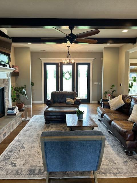 15172 S Henry Ln, Ashland, MO 65010 - living area with baseboards, a stone fireplace, wood finished floors, ceiling fan, and beam ceiling