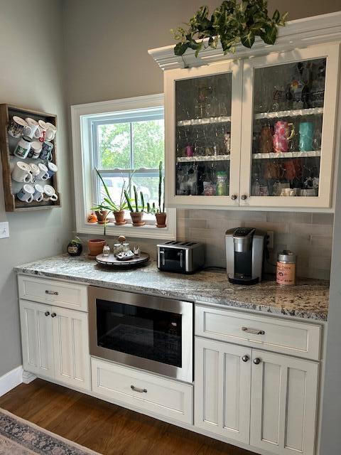 15172 S Henry Ln, Ashland, MO 65010 - bar area featuring built in microwave, decorative backsplash, and dark wood-type flooring