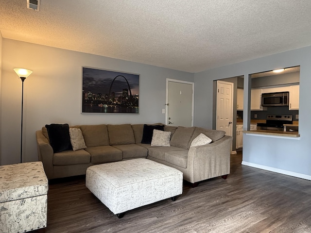 500 Columbia Dr Unit D, Columbia, MO 65203 - living room featuring a textured ceiling, dark wood-style floors, and baseboards