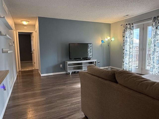 500 Columbia Dr Unit D, Columbia, MO 65203 - living area featuring a textured ceiling, dark wood-style flooring, and baseboards
