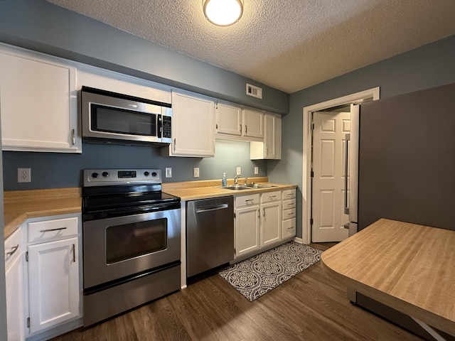 500 Columbia Dr Unit D, Columbia, MO 65203 - kitchen with appliances with stainless steel finishes, white cabinetry, a textured ceiling, and light countertops