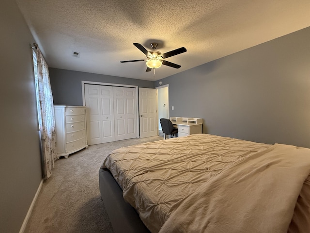 500 Columbia Dr Unit D, Columbia, MO 65203 - bedroom featuring carpet floors, a textured ceiling, baseboards, a closet, and a ceiling fan