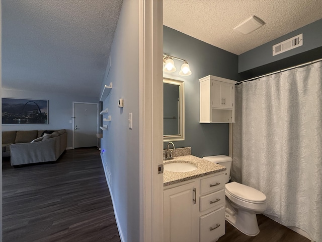 500 Columbia Dr Unit D, Columbia, MO 65203 - full bathroom featuring a textured ceiling, wood finished floors, toilet, vanity, and vaulted ceiling