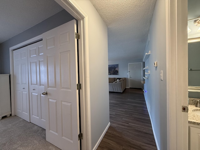 500 Columbia Dr Unit D, Columbia, MO 65203 - hall featuring a textured ceiling, baseboards, and dark wood-type flooring
