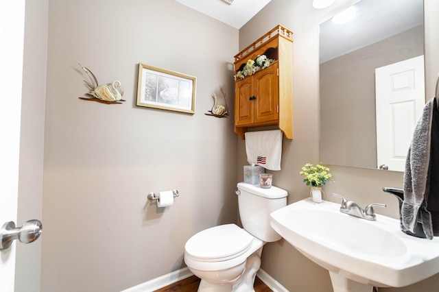 2803 Wooded Creek Dr, Columbia, MO 65203 - bathroom featuring toilet, a sink, wood finished floors, and baseboards