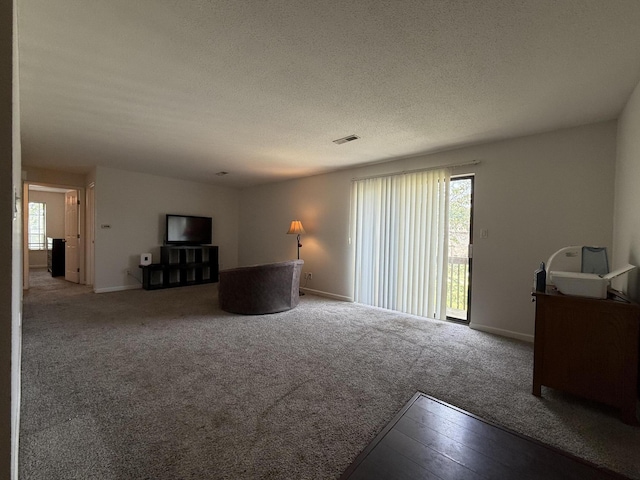 1999 N Waterfront Dr Unit H, Columbia, MO 65202 - carpeted living room with plenty of natural light, baseboards, and a textured ceiling