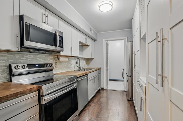 509 Columbia Dr Unit B, Columbia, MO 65201 - kitchen featuring appliances with stainless steel finishes, wooden counters, a sink, decorative backsplash, and dark wood-type flooring
