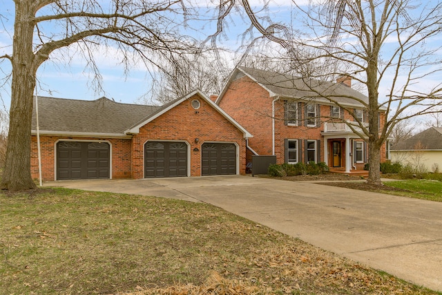 404 S Greenwood Ave, Columbia, MO 65203 - view of front of house featuring an attached garage, brick siding, a chimney, concrete driveway, and a balcony
