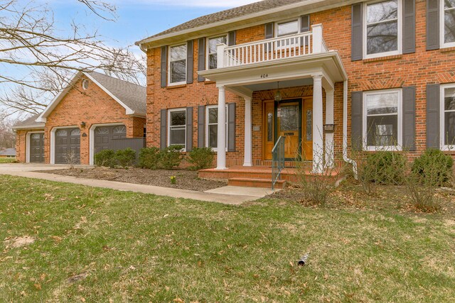 404 S Greenwood Ave, Columbia, MO 65203 - georgian-style home featuring a balcony, brick siding, a front yard, and a garage