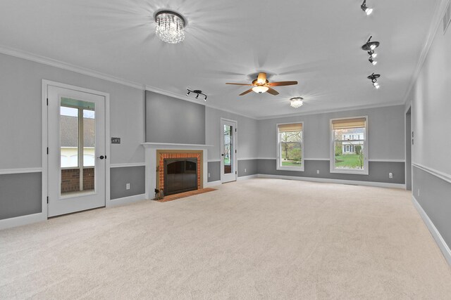 404 S Greenwood Ave, Columbia, MO 65203 - unfurnished living room with crown molding, track lighting, carpet flooring, a fireplace, and a ceiling fan