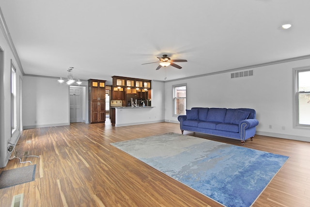 404 S Greenwood Ave, Columbia, MO 65203 - living area with crown molding, ceiling fan, baseboards, healthy amount of natural light, and wood finished floors