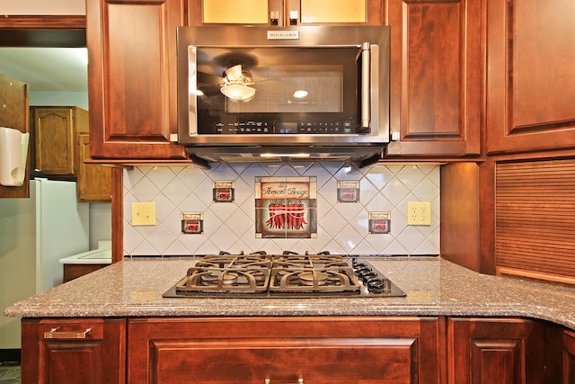 404 S Greenwood Ave, Columbia, MO 65203 - kitchen with stainless steel microwave, gas cooktop, tasteful backsplash, and dark brown cabinets