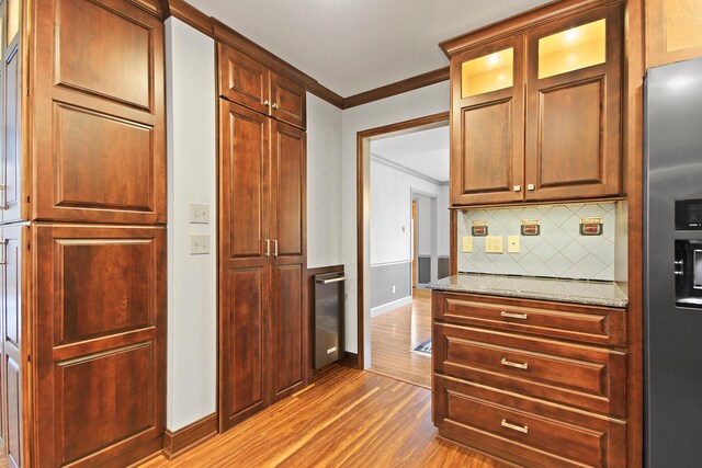 404 S Greenwood Ave, Columbia, MO 65203 - kitchen featuring crown molding, light wood finished floors, baseboards, tasteful backsplash, and stainless steel fridge with ice dispenser