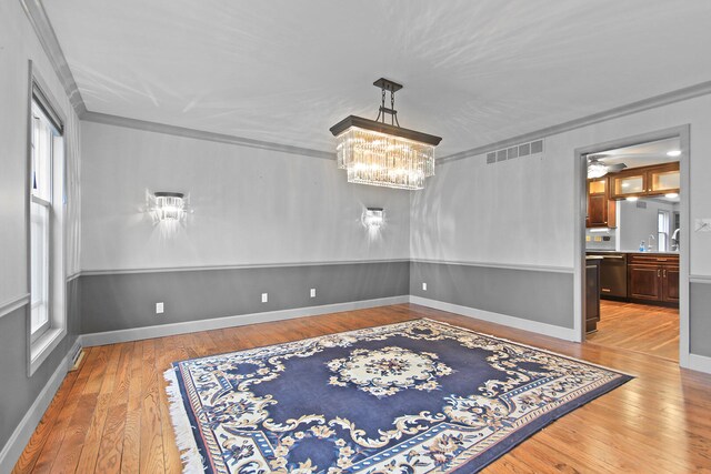 404 S Greenwood Ave, Columbia, MO 65203 - dining space with hardwood / wood-style floors, crown molding, a chandelier, and baseboards