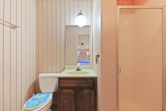 404 S Greenwood Ave, Columbia, MO 65203 - full bathroom featuring a stall shower, toilet, vanity, and wood walls
