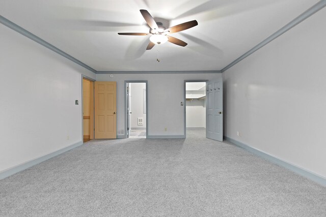 404 S Greenwood Ave, Columbia, MO 65203 - unfurnished bedroom featuring a walk in closet, carpet, ornamental molding, baseboards, and a ceiling fan