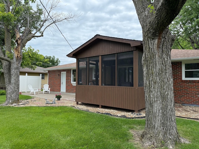 1609 Doris Dr, Columbia, MO 65202 - back of property featuring a sunroom, a patio area, brick siding, and an attached garage