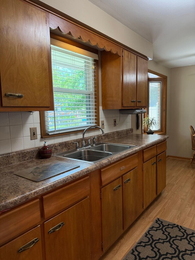 1609 Doris Dr, Columbia, MO 65202 - kitchen featuring a sink, tasteful backsplash, light wood-style floors, and brown cabinets