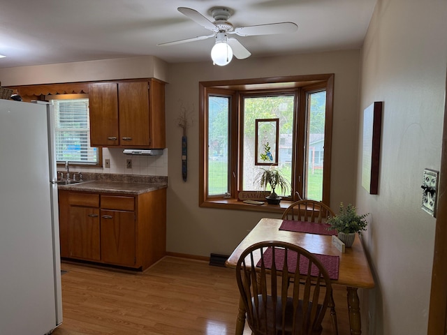 1609 Doris Dr, Columbia, MO 65202 - kitchen with freestanding refrigerator, brown cabinets, dark countertops, and healthy amount of natural light