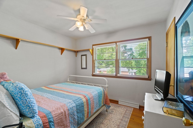 368 Crown Pt, Columbia, MO 65203 - bedroom featuring multiple windows, a baseboard heating unit, wood finished floors, and a ceiling fan