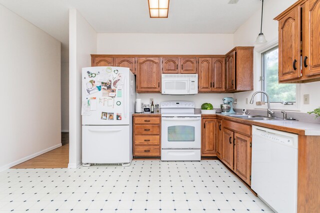 1411 Kinloch Ct, Columbia, MO 65203 - kitchen featuring white appliances, a sink, brown cabinetry, pendant lighting, and light floors