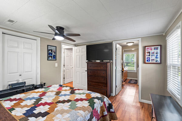 105 W Johnson Ave, Ashland, MO 65010 - bedroom featuring light wood-style floors, multiple windows, crown molding, a ceiling fan, and baseboards