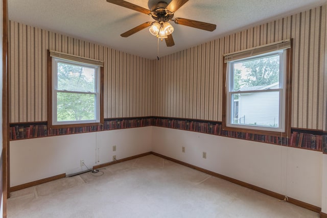606 Wientz St, Moberly, MO 65270 - unfurnished room featuring wallpapered walls, a textured ceiling, ceiling fan, carpet floors, and baseboards