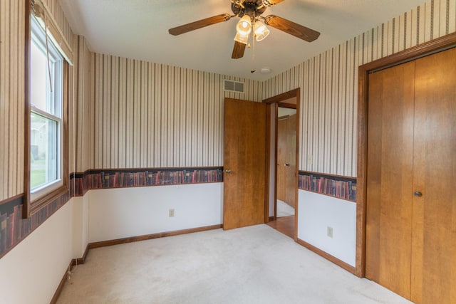 606 Wientz St, Moberly, MO 65270 - unfurnished bedroom featuring wallpapered walls, baseboards, carpet floors, a closet, and a ceiling fan