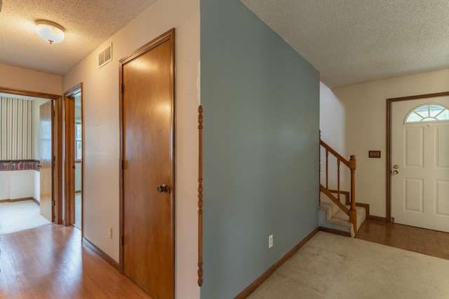 606 Wientz St, Moberly, MO 65270 - entryway with a textured ceiling, stairway, baseboards, and light wood-style floors