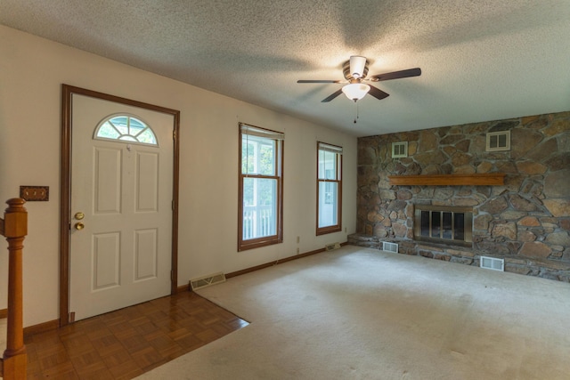 606 Wientz St, Moberly, MO 65270 - foyer entrance featuring a ceiling fan, a textured ceiling, a fireplace, and baseboards