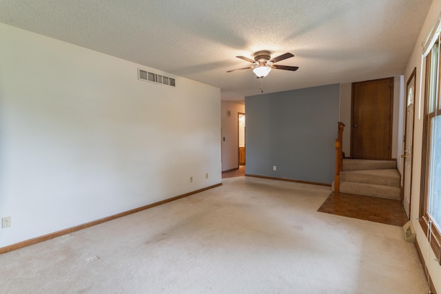 606 Wientz St, Moberly, MO 65270 - spare room with light colored carpet, ceiling fan, stairs, a textured ceiling, and baseboards