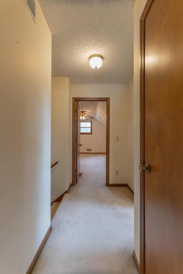 606 Wientz St, Moberly, MO 65270 - corridor with a textured ceiling, light colored carpet, an upstairs landing, and baseboards