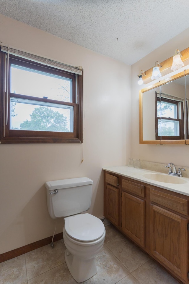 606 Wientz St, Moberly, MO 65270 - bathroom featuring toilet, tile patterned flooring, vanity, a textured ceiling, and healthy amount of natural light