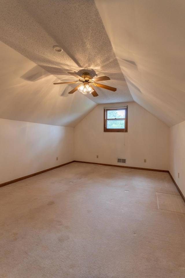 606 Wientz St, Moberly, MO 65270 - bonus room featuring lofted ceiling, light carpet, ceiling fan, baseboards, and a textured ceiling