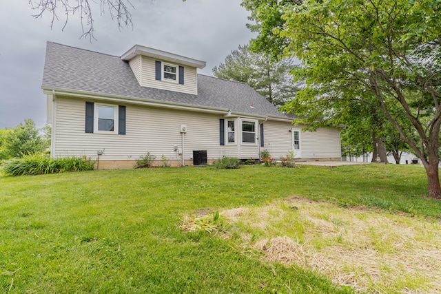 606 Wientz St, Moberly, MO 65270 - back of house featuring central AC unit, a lawn, roof with shingles, and a patio