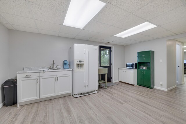 109 N Linnwood Dr, Linn, MO 65051 - kitchen featuring white refrigerator with ice dispenser, stainless steel microwave, light wood finished floors, a sink, and light countertops