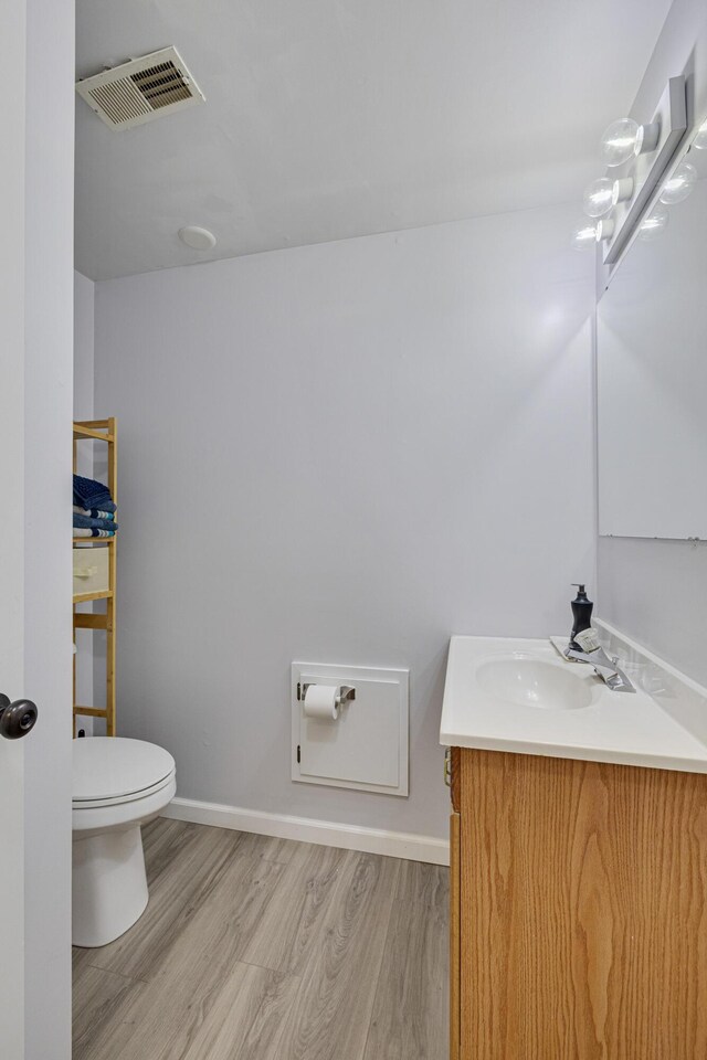 109 N Linnwood Dr, Linn, MO 65051 - half bath with toilet, vanity, wood finished floors, and baseboards