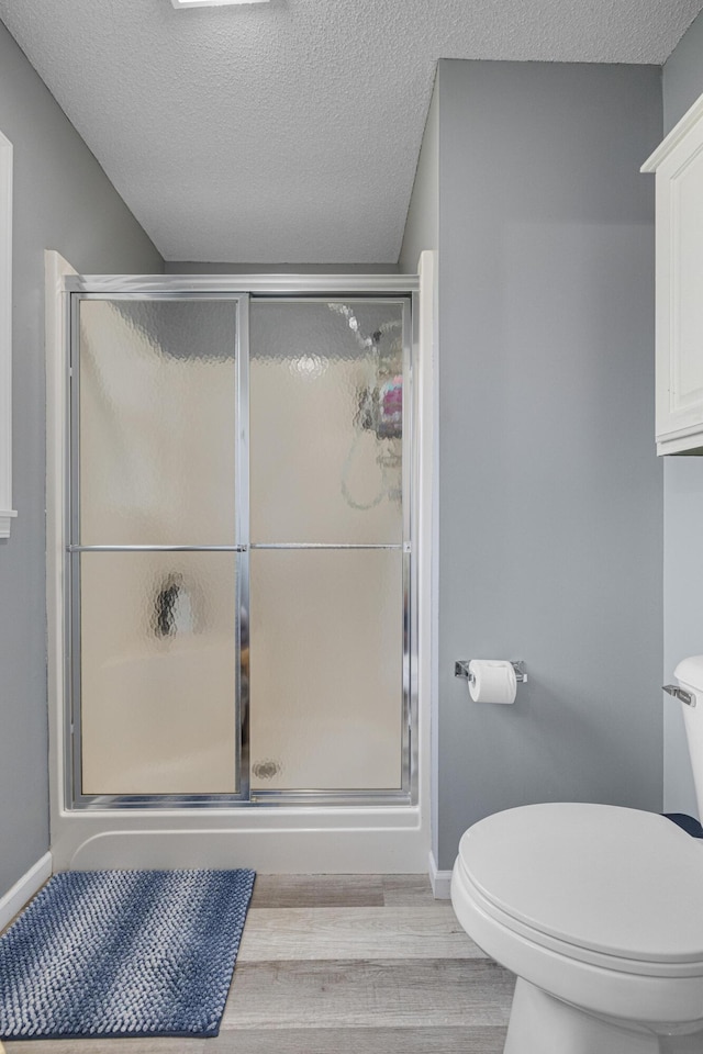 109 N Linnwood Dr, Linn, MO 65051 - full bath with wood finished floors, toilet, a stall shower, a textured ceiling, and baseboards