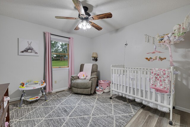109 N Linnwood Dr, Linn, MO 65051 - bedroom with wood finished floors, a nursery area, baseboards, a ceiling fan, and a textured ceiling