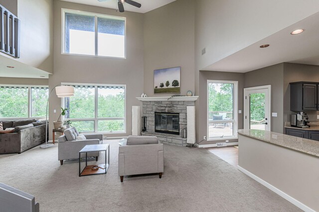 2416 Cimarron Dr, Columbia, MO 65203 - living area featuring carpet, ceiling fan, a high ceiling, a fireplace, and baseboards