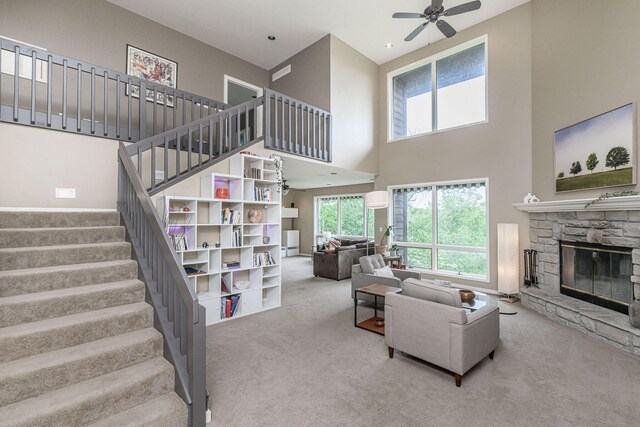 2416 Cimarron Dr, Columbia, MO 65203 - carpeted living area with a ceiling fan, a high ceiling, stairs, and a fireplace