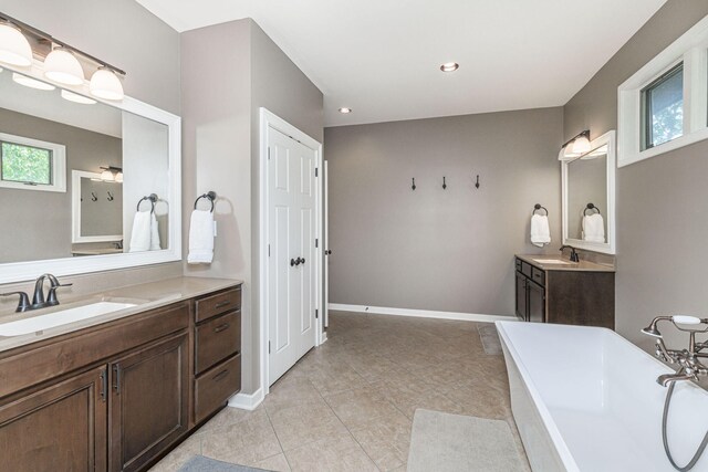 2416 Cimarron Dr, Columbia, MO 65203 - full bath with a soaking tub, two vanities, healthy amount of natural light, tile patterned flooring, and recessed lighting