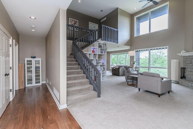 2416 Cimarron Dr, Columbia, MO 65203 - stairway featuring a high ceiling, a ceiling fan, wood finished floors, a fireplace, and baseboards